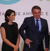 Bolsonaro, ao lado da mulher, Michele, faz gesto de arma com a mo