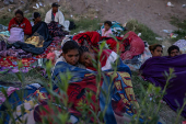 Migrants snuggle for warmth along international border between Mexico and United States