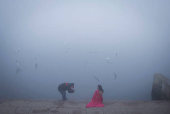 A girl gets her picture clicked on the banks of the Yamuna river on a foggy winter morning in New Delhi