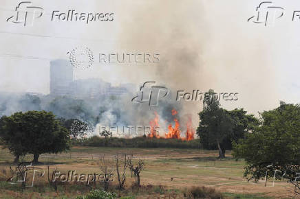 FILE PHOTO: Smoke billows from a field which caught fire on a hot summer day during a heatwave in New Delhi