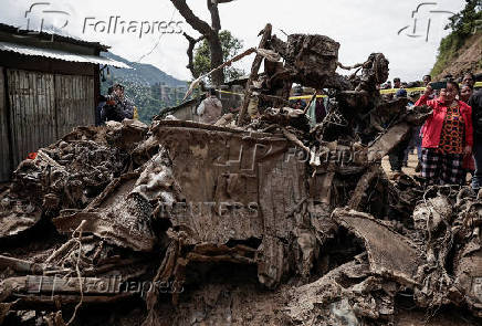 Rescue personnel work to retrieve the bodies of victims from a landslide triggered by heavy rainfall, in Dhading