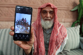 Akram Shalbout, a Syrian living in Jordan, shows an image on his phone, in Irbid