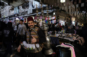 Abu Mohamed, a tamarind juice seller, poses for a photograph at the old city, in Damascus