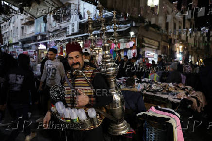 Abu Mohamed, a tamarind juice seller, poses for a photograph at the old city, in Damascus