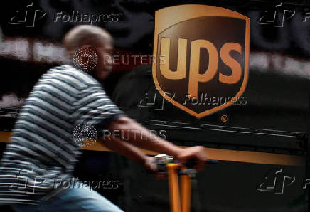 FILE PHOTO: A bicycle delivery man rides past a UPS truck in New York's Times Square