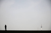 A man takes photographs of N Seoul Tower at National Museum of Korea in Seoul