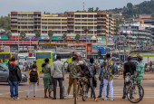 Pedestrians wait to cross a street in Kigali