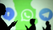 FILE PHOTO: Silhouettes of mobile users are seen next to logos of social media apps Signal, Whatsapp and Telegram projected on a screen in this picture illustration