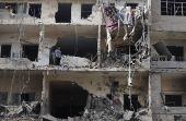 A boy looks out from a damaged building in Beirut's southern suburbs