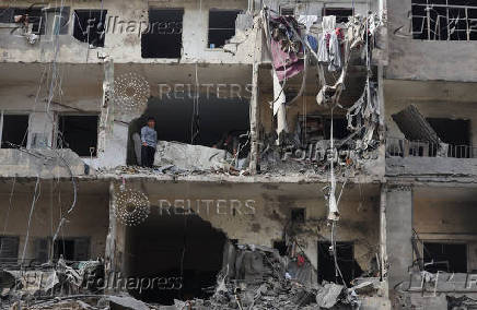 A boy looks out from a damaged building in Beirut's southern suburbs