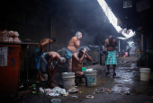 Migrant labourers take bath from a municipal tap at a market area on a cold winter morning in the old quarters of Delhi