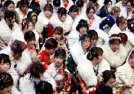 Kimono-clad young women leave the venue after their Coming of Age Day celebration ceremony in Yokohama