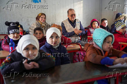 UNICEF Deputy Executive Director, Ted Chaiban, sits with children inside a portable classroom during his visit to a damaged school in Aleppo