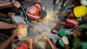 Palestinians work to rescue a child from under the rubble following an Israeli strike, amid the Israel-Hamas conflict, in Nuseirat in the central Gaza Strip