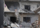 A man clears debris from an apartment in Beirut's southern suburbs