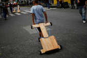 Government supporters participate in a traditional street race with wooden makeshift carts called 