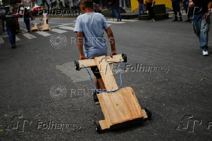 Government supporters participate in a traditional street race with wooden makeshift carts called 