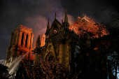 FILE PHOTO: Sparks fill the air as Paris Fire brigade members spray water to extinguish flames as the Notre Dame Cathedral burns in Paris