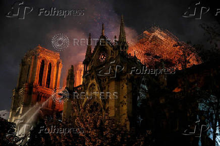 FILE PHOTO: Sparks fill the air as Paris Fire brigade members spray water to extinguish flames as the Notre Dame Cathedral burns in Paris