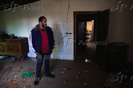 A resident of Baalbek, Abbas Wehbe, stands inside his damaged house, in Baalbek