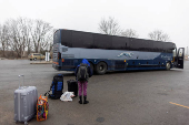 FILE PHOTO: People wait for transport to cross into Canada at Roxham Road, in Plattsburgh