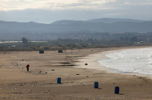 A man jogs on a beach in Tyre