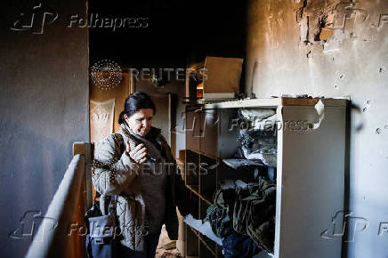 A woman inspects the damage caused by projectiles fired from Lebanon, following the ceasefire between Israel and Iran-backed group Hezbollah, in Metula