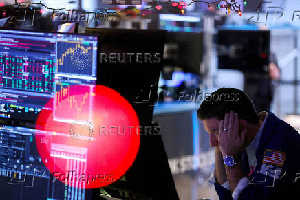 FILE PHOTO: FILE PHOTO: A trader works on the trading floor at the New York Stock Exchange (NYSE) in New York City