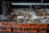 An employee puts packages of meat on display for sale in a butcher's shop, in Monterrey
