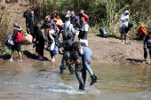 Alawite Syrians, who fled the violence in western Syria, walk at the water of Nahr El Kabir, in Akkar