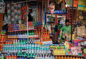 A vendor selling snacks and refreshment drinks waits for customers outside Alipore Zoological Garden on a hot summer day in Kolkata