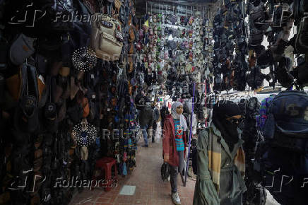 Women walk along the market, in Douma