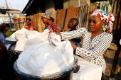 FILE PHOTO: A vendor sells cassava flour at a traditional market in Bariga district, in Lagos