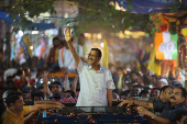 People gather as Delhi's Chief Minister Arvind Kejriwal attends a roadshow, in New Delhi