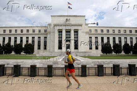 FILE PHOTO: A jogger runs past the Federal Reserve building in Washington, DC