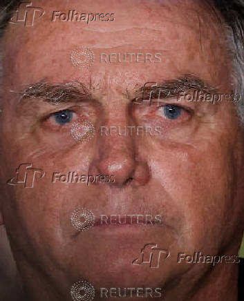 Brazil's former President Jair Bolsonaro talks with media upon his arrival at Brasilia International Airport