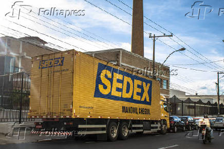 Caminhões e veículos dos Correios utilizam calçada como