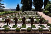 Israeli soldiers place Israeli flags on the graves of fallen soldiers, ahead of Israel's Memorial Day due to begin next week, at Mount Herzl military cemetery in Jerusalem