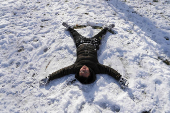 Edgar Tan, 12, makes a snow angel in Central Park, in New York