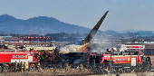 Firefighters carry out extinguishing operations on an aircraft which drove off runway at Muan International Airport in Muan