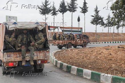 Rebel fighters sit on a vehicle in Homs countryside