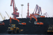 FILE PHOTO: Workers operate loaders unloading imported coal at a port in Lianyungang, Jiangsu