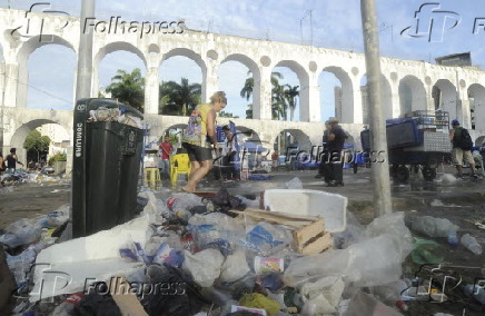 Vendedora ambulante varre lixo