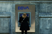 A woman uses a BBVA bank ATM machine in the Gran Via of Bilbao