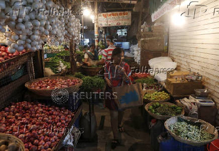FILE PHOTO: A woman shops at a vegetable market in a residential area in Mumbai