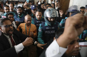 Chinmoy Krishna Das, a Hindu leader associated with the International Society for Krishna Consciousness (ISKCON), is escorted by the police at the Chattogram Metropolitan Magistrate Court, in Chattogram