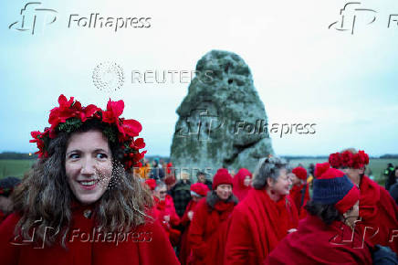 Revellers attend winter solstice celebrations during sunrise at Stonehenge stone circle near Amesbury