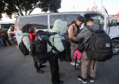 Migrants prepare to board a van to take them to a shelter at El Chaparral border crossing after their CBP One app asylum appointment was cancelled on the day of U.S. President Donald Trump's inauguration, in Tijuana