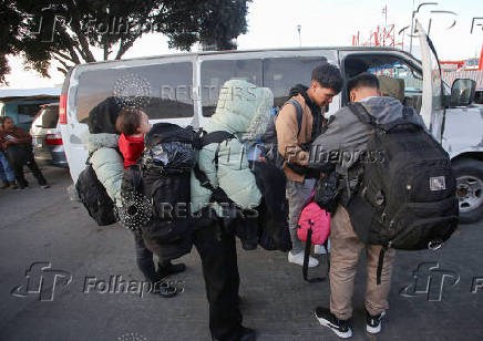 Migrants prepare to board a van to take them to a shelter at El Chaparral border crossing after their CBP One app asylum appointment was cancelled on the day of U.S. President Donald Trump's inauguration, in Tijuana