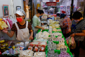 A shopkeeper sells products at a market in Taipei